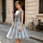 Elegantes Cocktailkleid in Silbergrau mit U-Boot-Ausschnitt, Spitzenstickerei und A-Linie